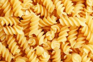 Background texture and pattern of boiled egg noodles in a spiral or pasta spaghetti screw. in full frame. View from above photo