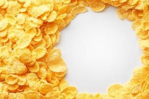 Golden cornflakes on full frame with empty white space. Healthy breakfast photo