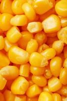 Golden canned corn, as distributed on a plane background and texture of popcorn. Before watching a movie top view. Close-up photo