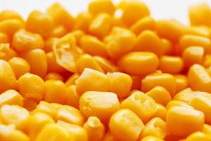 Golden canned corn, as distributed on a plane background and texture of popcorn. Before watching a movie top view. Close-up photo