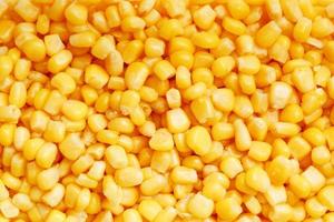 Golden canned corn, as distributed on a plane background and texture of popcorn. Before watching a movie top view. Close-up photo