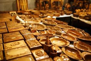 Wood products, jewelry boxes, cups, mugs and spoons on the counter of the Goa night market photo