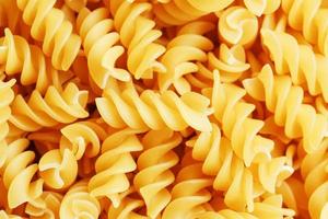 Background texture and pattern of boiled egg noodles in a spiral or pasta spaghetti screw. in full frame. View from above photo