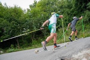 Zogno Italy 2022  Cross-country skiers train with Skiroll on uphill road photo