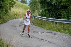Zogno Italy 2022  Cross-country skiers train with Skiroll on uphill road photo