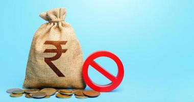 Indian rupee money bag and red prohibition sign NO. Monetary restrictions, freezing of bank accounts. Termination projects. Monitoring suspicious money flows. Confiscation of deposits. photo