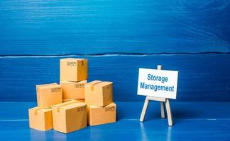 Pile of boxes and storage management easel. A set of measures for the effective organization of storage of goods in the warehouse, automation and accounting. Simplification of bureaucratic procedures. photo