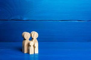 Family figures of parents and kids on a blue background. Family values and health. Adoption and custody of children. Social support, demography, sociology. Upbringing and education. Together concept photo