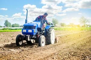 Farmer on a tractor loosens the soil with milling equipment. Loosening surface, land cultivation Use of agricultural machinery and to simplify and speed up work. Farming, agriculture. Plowing field. photo