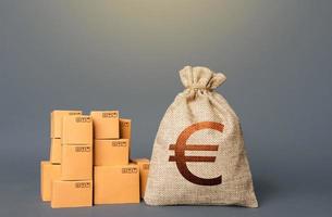 Boxes and Euro money bag. The concept of trade in goods and production. Business industry. Delivering. Profit from trading. Financial success. GDP and economy. Import export. Warehousing logistics. photo