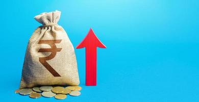 Indian rupee money bag with red arrow up. Raising taxes. Deposit interest. Increase in profitability and prosperity, higher living standards. Recovery of financial system after crisis. Budget growth photo