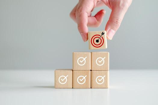 Checklist, Task list, Survey and assessment, Quality Control, Goals achievement and business success. To do list. Check mark and Hand holding dartboard from top of wooden stacks photo