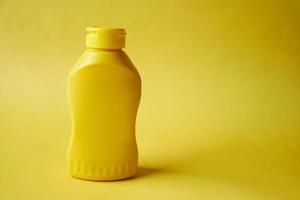 mustard mayonnaise in yellow container on yellow background photo