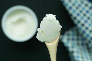 yogur fresco en la vista superior de una cuchara de madera foto