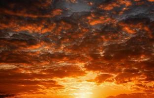 Sunset dramatic sky with bright orange and dark red stormy clouds. Nature background photo