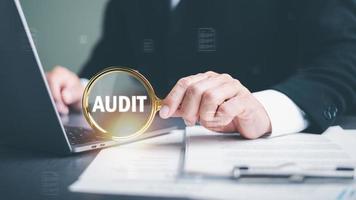 Businessman Audit documents with a magnifying glass, Quality Assessment Management with checklists, business document evaluation processes, market data report analysis and consulting photo