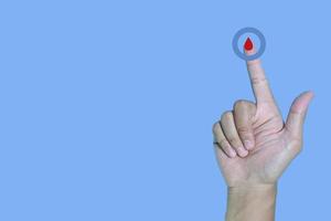 Top view inscription world diabetes day and hand gesture with red blood drop in man hands isolated on a blue background. World diabetes day, 14 november. Copy space., Health Awareness photo