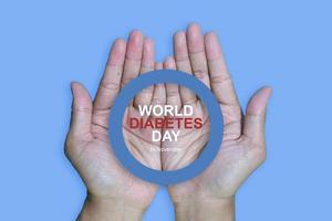 Top view inscription world diabetes day and hand gesture with red blood drop in man hands isolated on a blue background. World diabetes day, 14 november. Copy space., Health Awareness photo