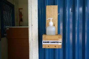 Sangatta, East Kutai, East Kalimantan, Indonesia, 2022 - Hand sanitizer in front of the office door.  Coronavirus pandemic prevention with wash hands with hand sanitizer. photo