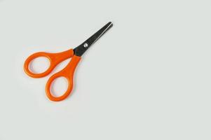 orange color scissors isolated on white background. photo