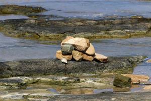 las piedras yacen a orillas del mar mediterráneo. foto