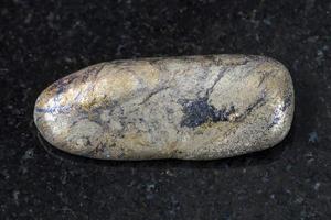 pebble of Arsenopyrite stone on dark background photo