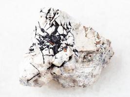 Ilmenite black crystals on stone on white photo