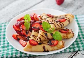 tortitas con fresas y chocolate decoradas con hojas de menta foto