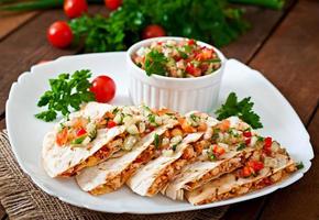 Mexican Quesadilla wrap with chicken, corn and sweet pepper and salsa photo