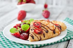 tortitas con fresas y chocolate decoradas con hojas de menta foto