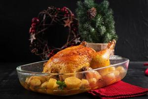 Baked turkey or chicken. The Christmas table is served with a turkey, decorated with bright tinsel. Fried chicken, table. Christmas dinner. photo