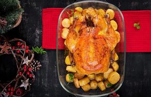Baked turkey or chicken. The Christmas table is served with a turkey, decorated with bright tinsel. Fried chicken, table. Christmas dinner.  Top view, above