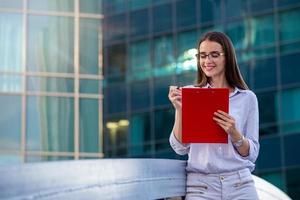 Executive business woman with clipboard against the urban background photo