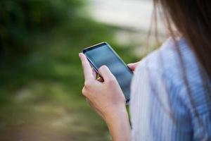 Close up of women's hands holding cell telephone with blank copy space scree for your advertising text message or promotional content photo