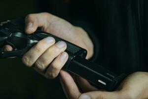 Close up of man reloading pistol. photo