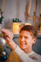 Smiling guy decorating Christmas tree. photo