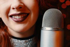 Smiling female singer's and retro microphone on bokeh blur background. photo