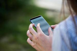 Close up of women's hands holding cell telephone with blank copy space scree for your advertising text message or promotional content photo