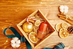 Flat lay of Christmas gift box and decorations on wooden table. photo