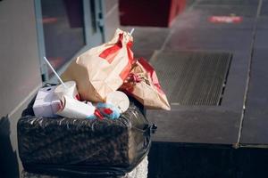 bote de basura de hormigón con bolsa negra en el interior. foto