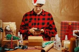 Man in plaid shirt with mobile phone in holiday decorations. photo