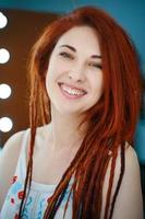 Smiling red-haired girl with long dreadlocks. photo