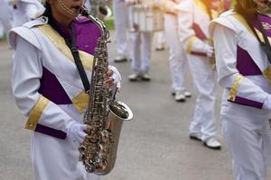 Orchestra students play saxophones in a parade at the school's athletics event. Soft and selective focus. photo