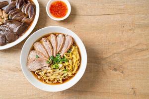 egg noodles with stewed duck in brown soup photo