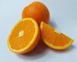 Cut and whole fresh ripe oranges on white background photo