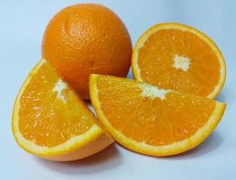 Cut and whole fresh ripe oranges on white background photo