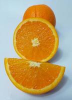 Cut and whole fresh ripe oranges on white background photo