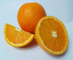 Cut and whole fresh ripe oranges on white background photo