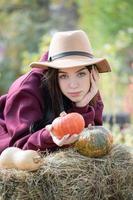 niña feliz con calabaza en el jardín de otoño foto