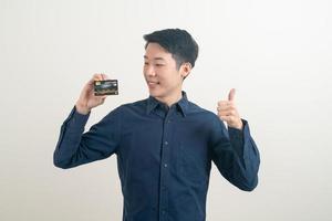 young Asian man holding credit card photo